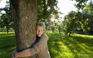 Mature_woman_embracing_tree__eyes_closed__tree_hugging__tree_huggers_810_500_75_s_c1.jpg