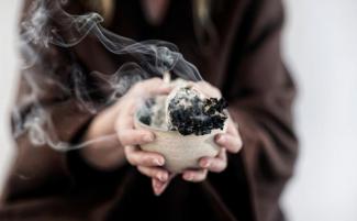 Hands_of_a_spiritual_woman_holding_burning_smoking_Sage_Smudge_stick__smudging_810_500_75_s_c1.jpg