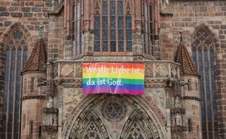 German-church-with-Pride-flag-scaled-810x500.jpg